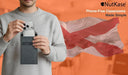 Person placing a smartphone into a gray NutKase school phone pouch with the Alabama flag in the background.